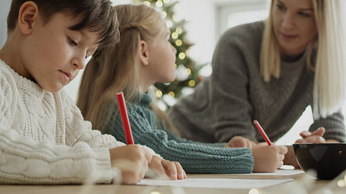 Video of children focused on writing letter to Santa Claus