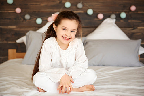 Portrait of smiling girl sitting on bed