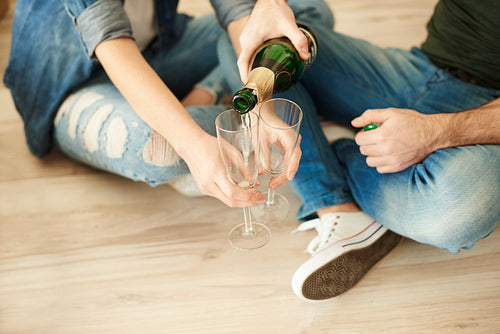 Couple cheering new life with glass of champagne