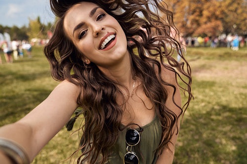 Smiling caucasian woman making selfie at music festival