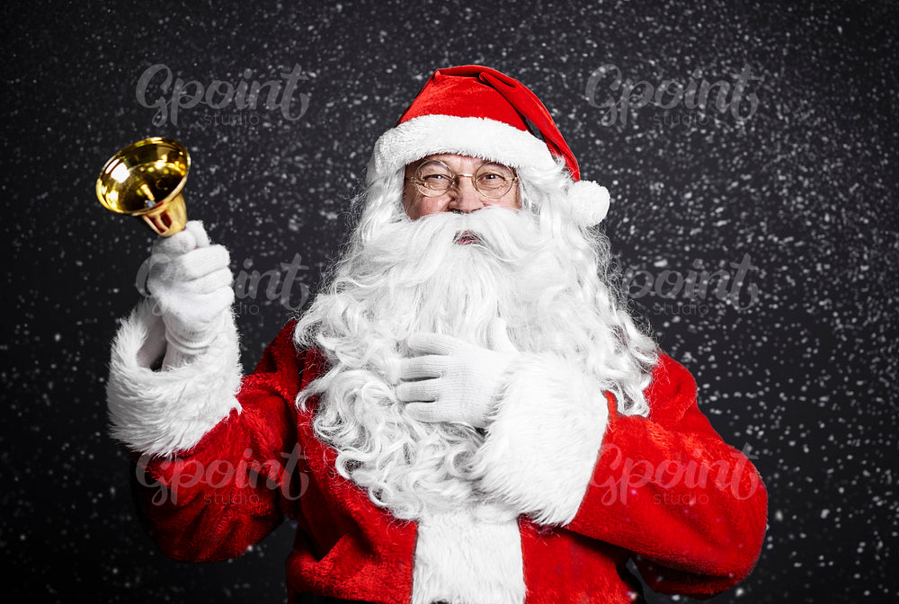 Cheerful santa claus holding handbell