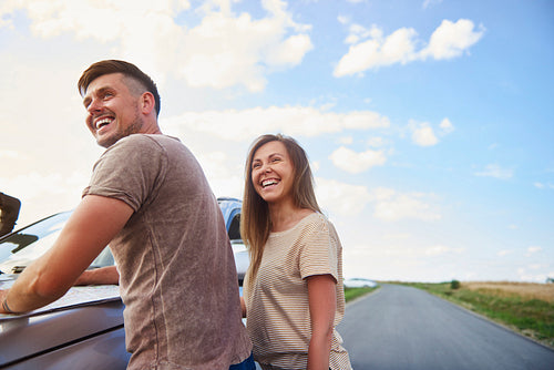 Cheerful couple catching a break during summer road trip