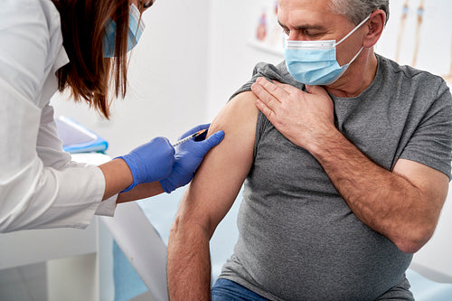 Close up of senior being vaccinated in a doctor's office