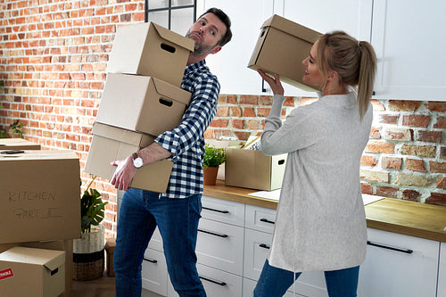 Couple during moving out takes cardboard boxes
