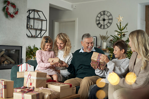 Multi generation caucasian family opening Christmas presents at home