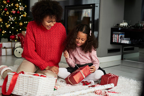 African woman and her daughter wrapping Christmas presents
