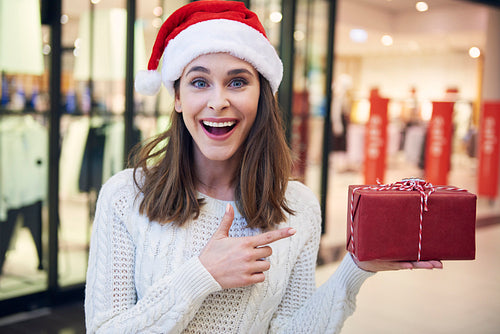 Portrait of excited woman pointing at christmas present