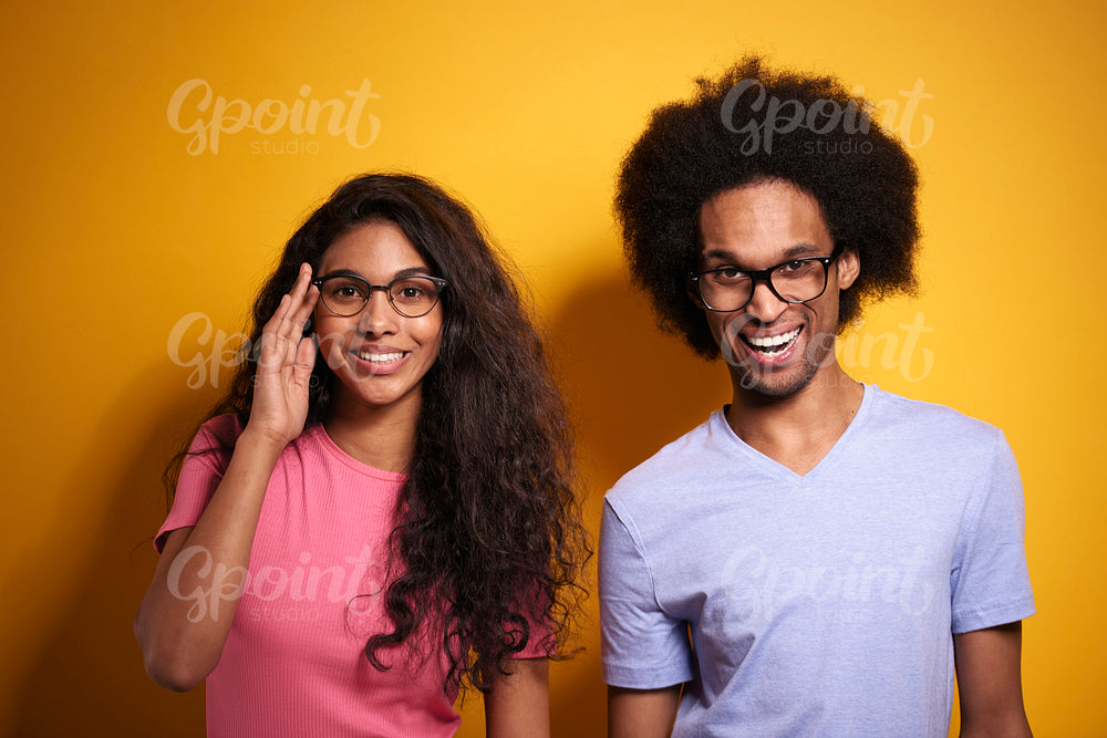 Afroamerican couple in glasses on yellow background