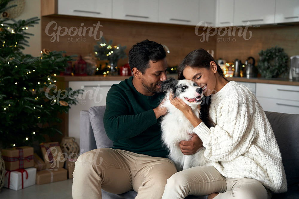 Multi ethnicity couple bonding with dog at Christmas time 