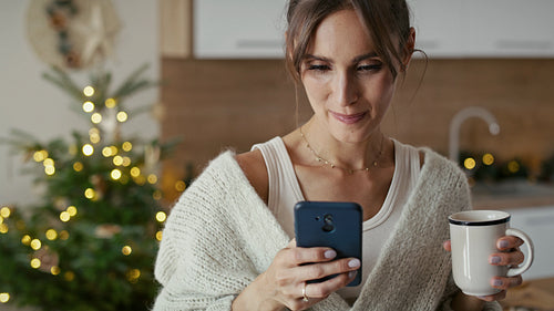 Caucasian woman with cup and mobile phone in Christmas time