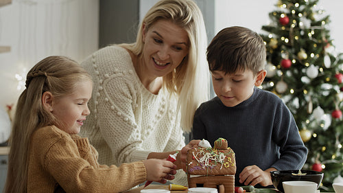 Video of children and mother decorating gingerbread house