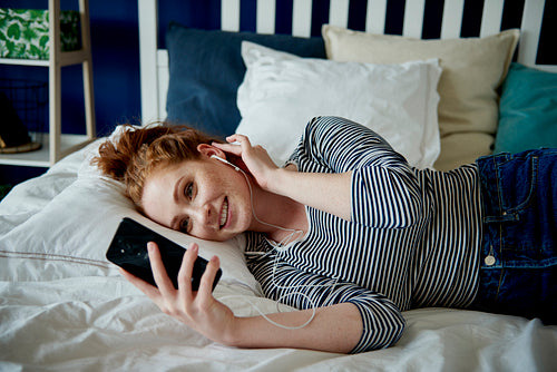 Redhead woman having a videoconference in her bed