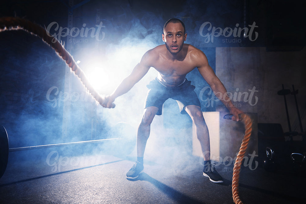 Full length of man exercising with ropes