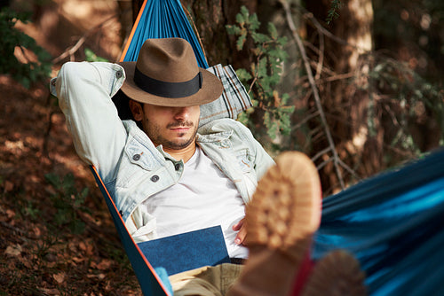 Man relaxing on hammock in forest