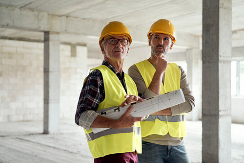 Two caucasian engineers discussing on construction site