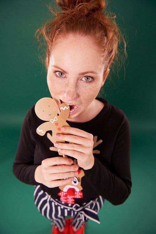 Young woman eating gingerbread man