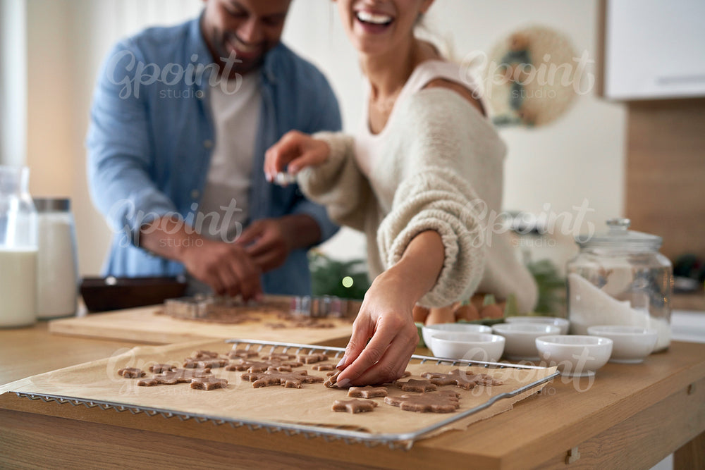 Multi ethnicity couple making a gingerbreads in Christmas time