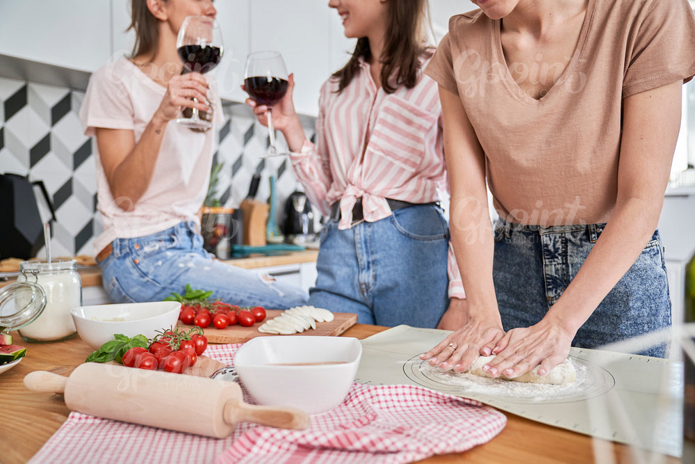 Girls having good time with homemade pizza and wine
