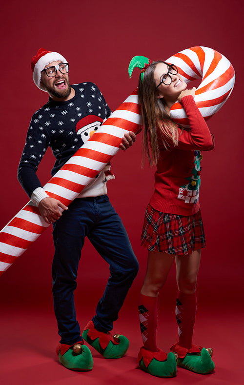 Couple carrying heavy candy cane