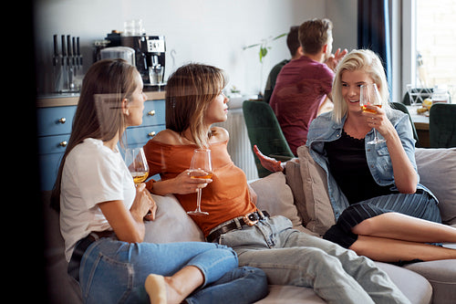 Female friends chatting and drinking wine