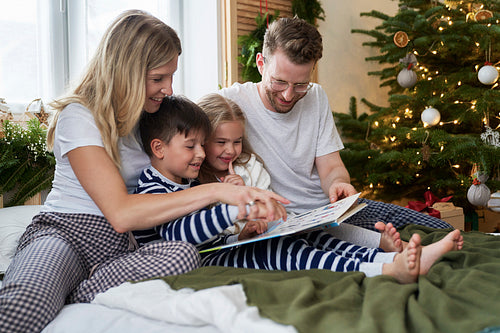 Family reading books at Christmas morning