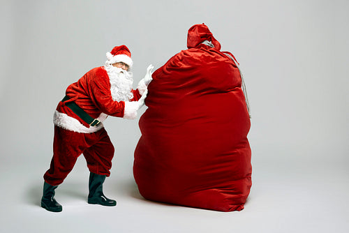 Caucasian Santa Claus with huge sack of Christmas presents
