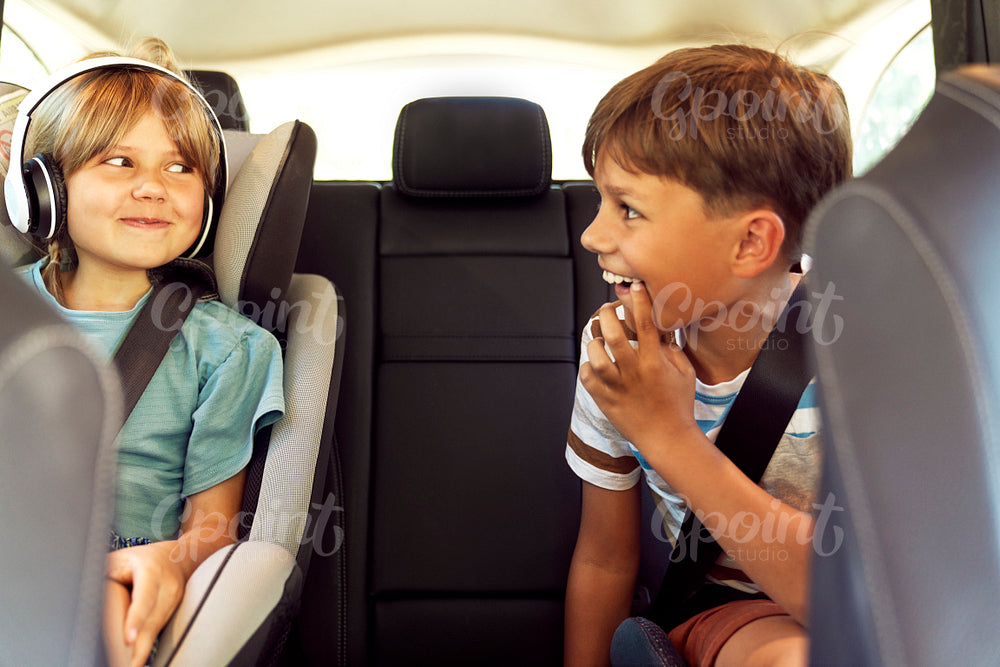 Happy siblings on rear seat of car