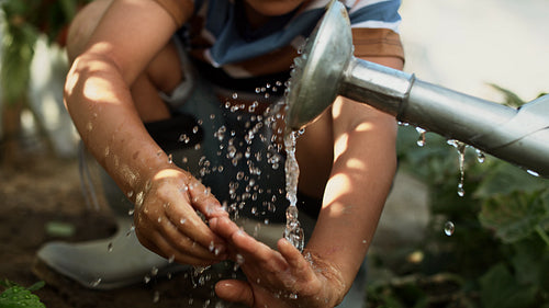 Video of boy washing his hands at the watering can