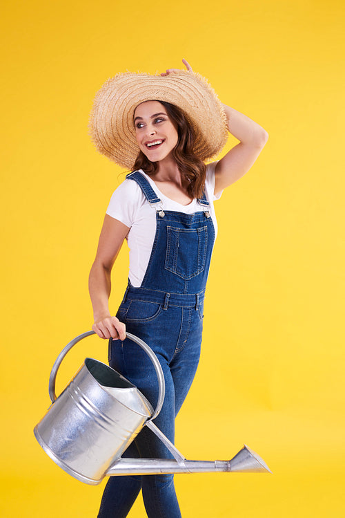 Beautiful woman with watering can in studio shot