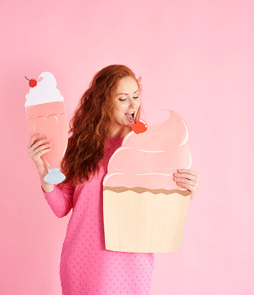 Young woman eating a cupcake at studio shot