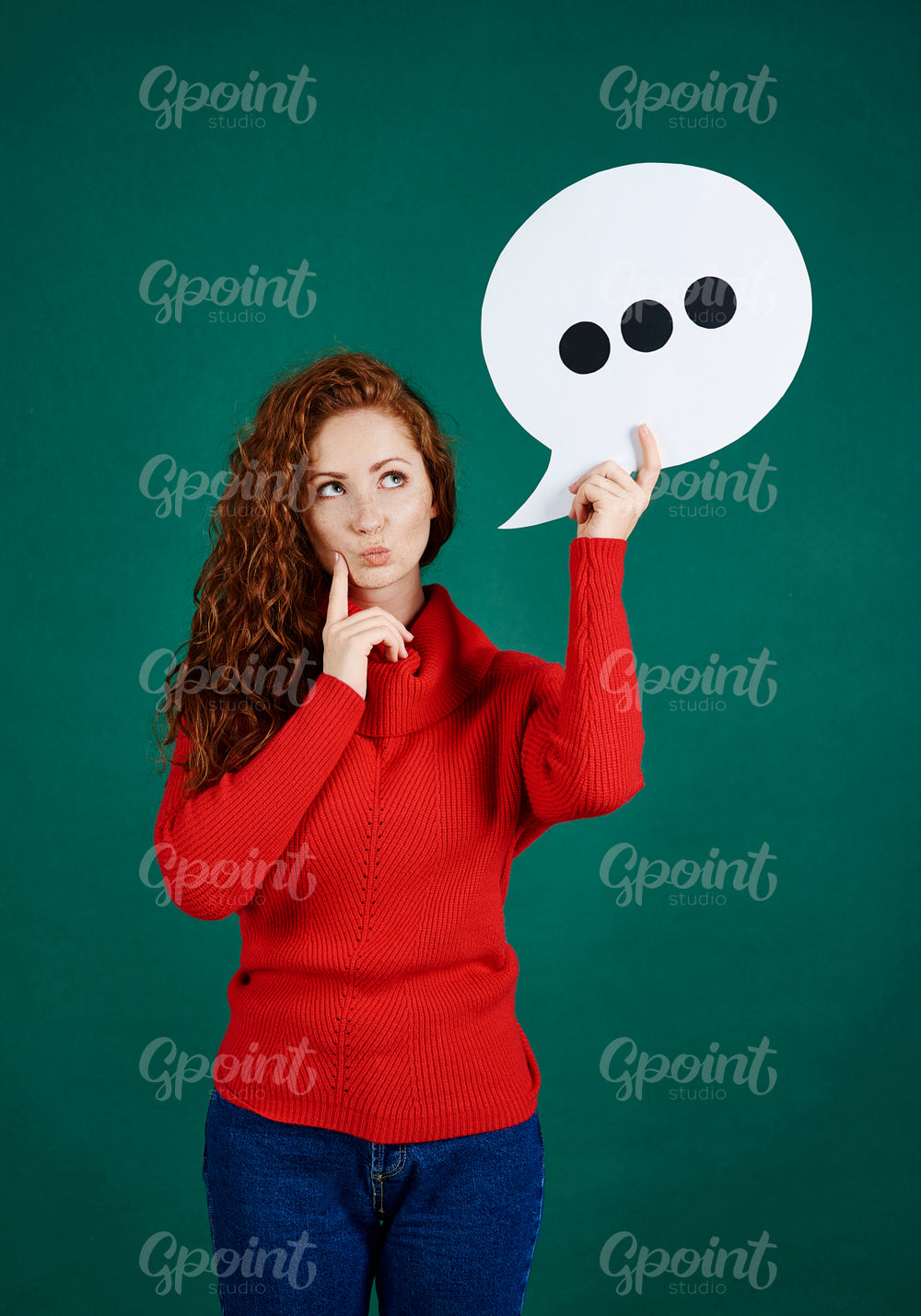Confused girl holding speech bubble and looking at copy space