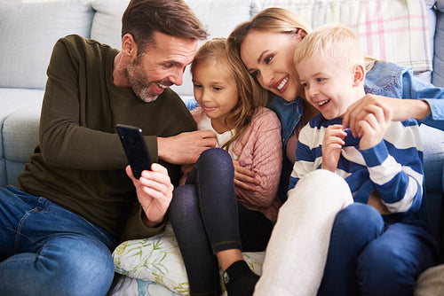 Family using mobile phone in living room