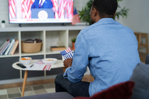 Rear view of  affectionate man watching USA election on TV