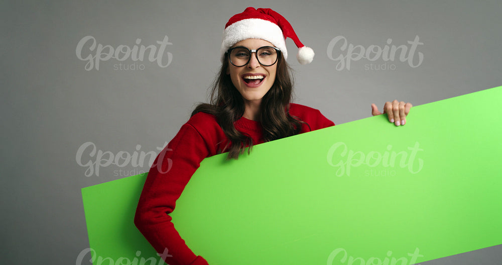 Woman pointing on Christmas banner with copy space