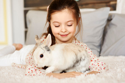 Affectionate girl playing with rabbit