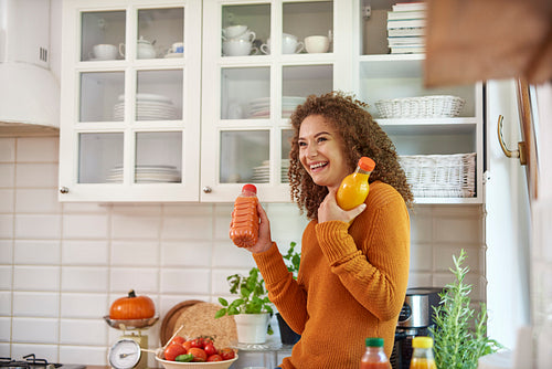 Young woman holding two bottle of fruity juices