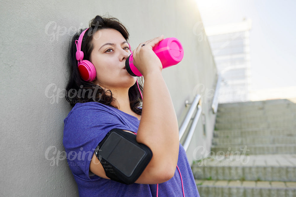 Female athlete drinking water after really hard workout