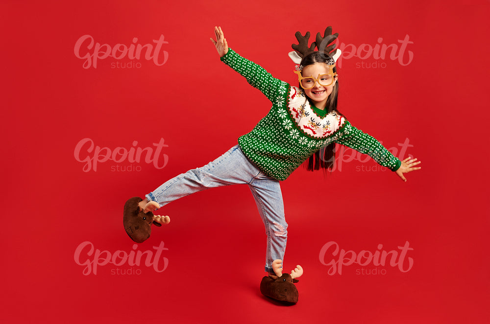 Child in Christmas clothes on red background