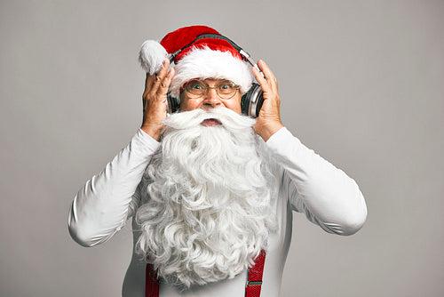 Caucasian Santa Claus on grey background wearing headphones set