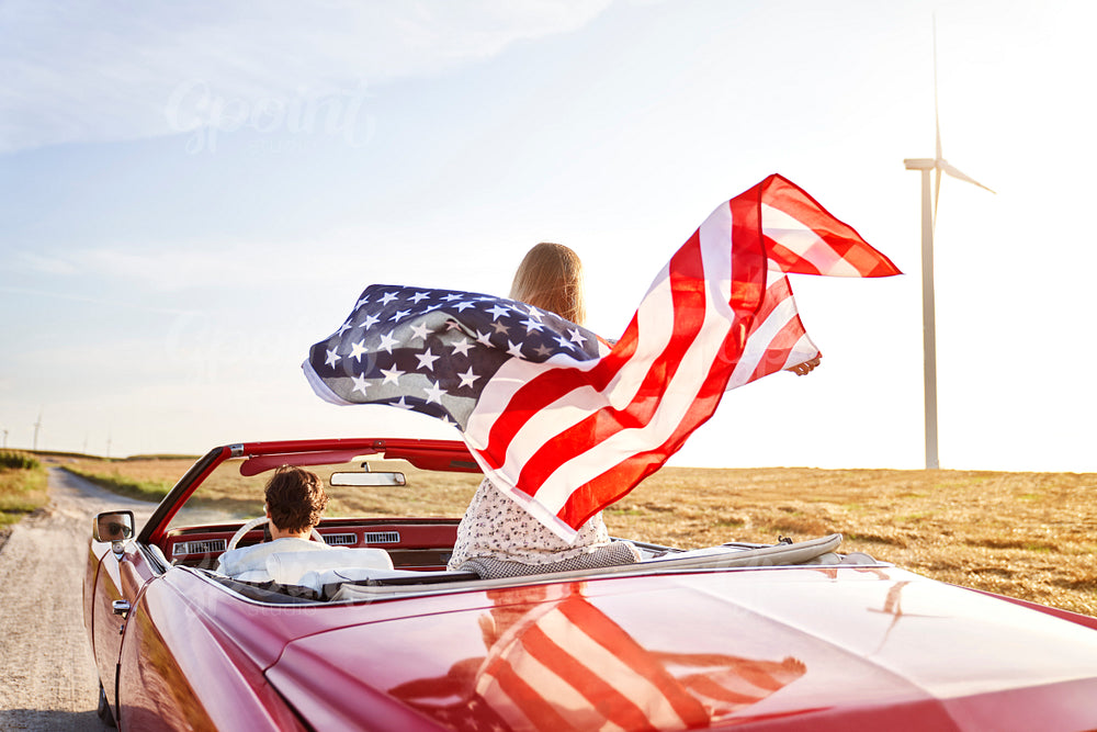 Woman holding an American flag on a road trip