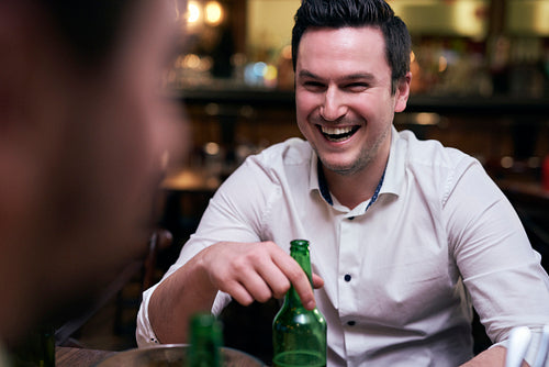 Joyful man drinking beer in the pub