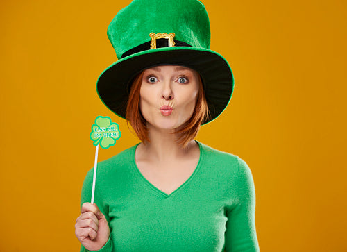 Happy leprechaun with green hat blowing a kiss