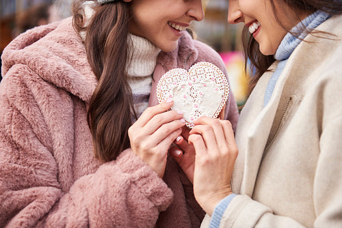 Women connected with a heart shape gingerbread cookie