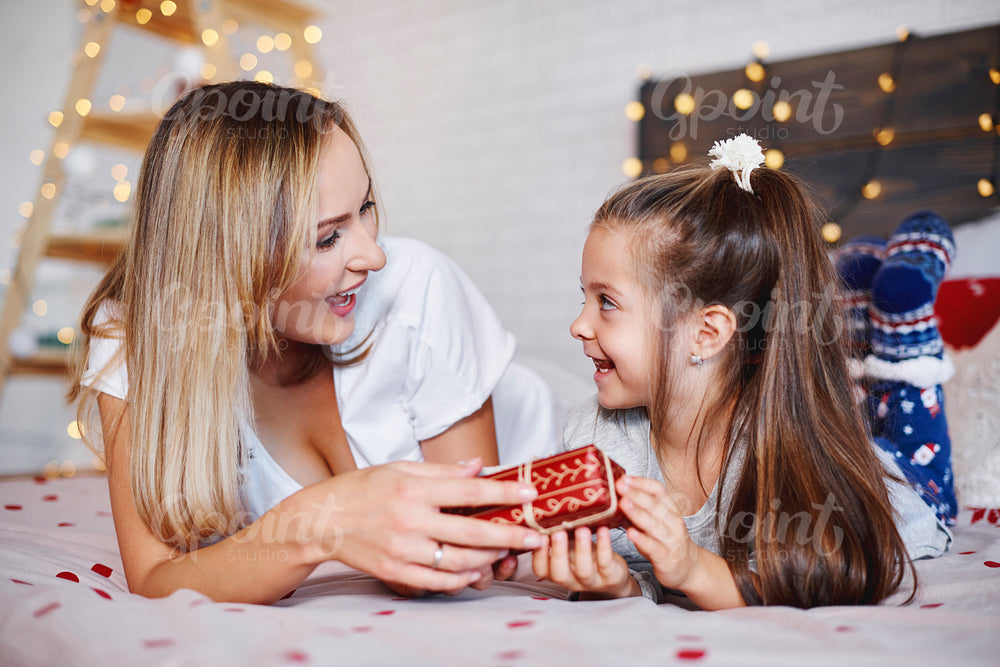 Girl giving christmas present to her mom
