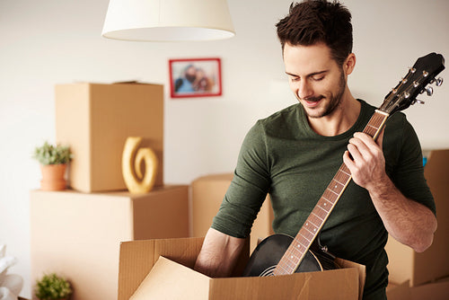 Man unpacking guitar from the cardboard box