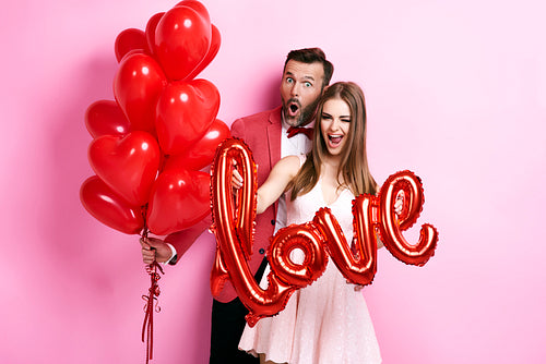 Man with balloon embracing his girlfriend