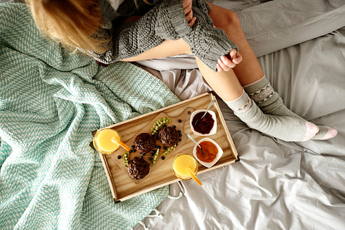 Unrecognizable woman and breakfast on bed