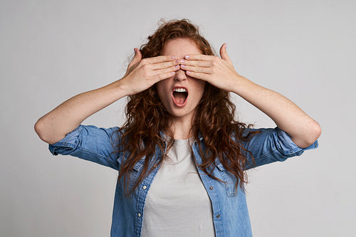 Woman covering her eyes and screaming
