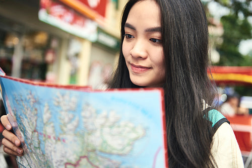 Asian woman using paper map on the street