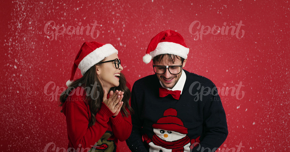 Happy nerd couple surrounded in snowflakes